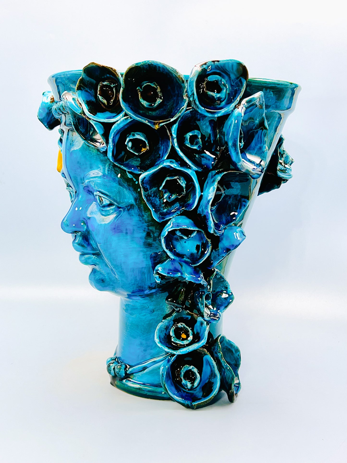 Cabeza recipiente decorada con collar y flores turquesa