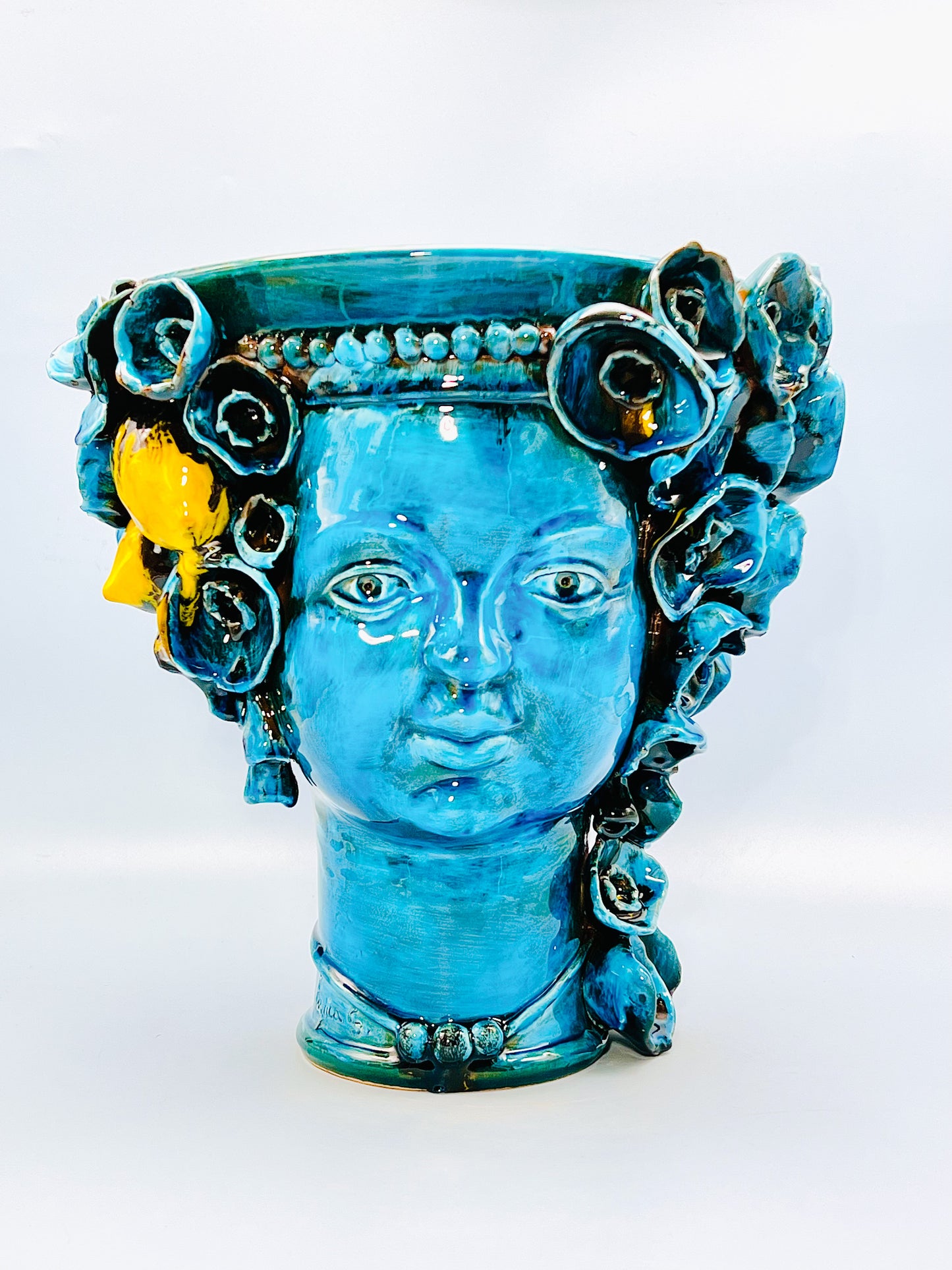 Cabeza recipiente decorada con collar y flores turquesa