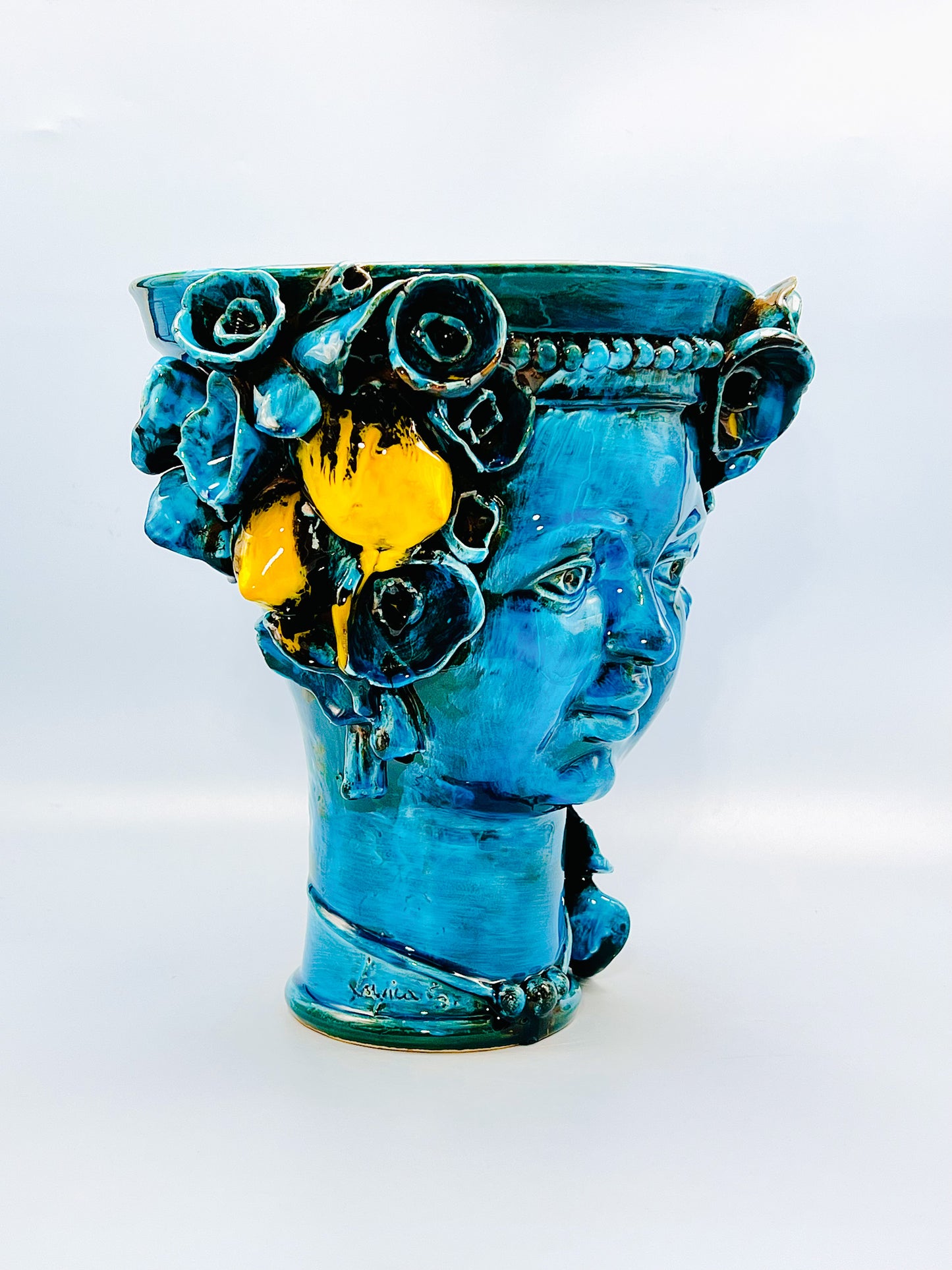 Cabeza recipiente decorada con collar y flores turquesa
