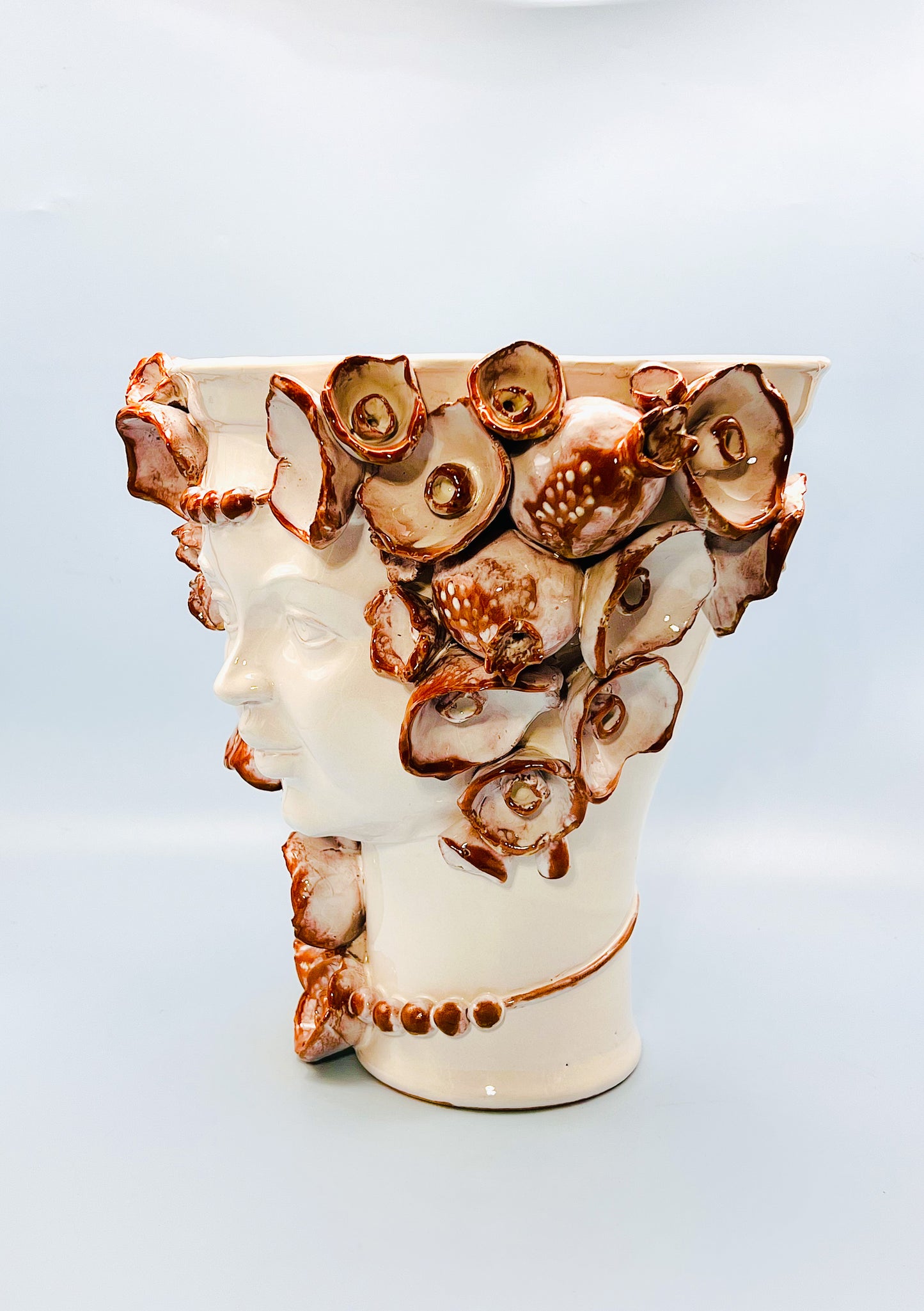 Cabeza recipiente decorada con collar y flores